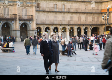 Spanien Salamanca älteres Ehepaar gehen gemeinsam durch Plaza Mayor öffentlicher Platz im 1700 s Massen von Menschen und Tour Gruppen gebaut Stockfoto