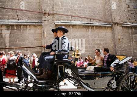 Spanien Toledo Braut und Bräutigam in Pferdekutsche verlassen Kirche und Parade Stadt Straße Fahrer und Begleiter in uniform Stockfoto