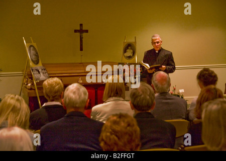 Ein Priester führt Gebete in eine katholische aufwachen in Stoneham MA Hinweis geschlossen Sarg und Fotografien des Verstorbenen auf dem Display Stockfoto