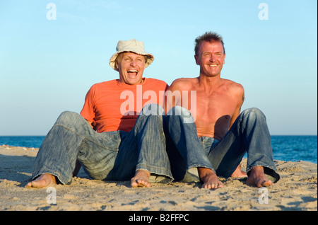 Ein glückliches Homosexuell Paar haben Spaß am Strand zusammen während ihrer Sommerferien. Stockfoto