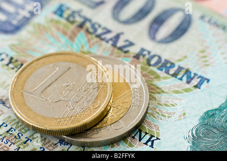 Euro-Münzen sitzen an der Spitze der ungarischen Forint Banknoten Stockfoto