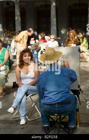 Spanien Toledo Mann mit Stroh Hut ziehen Gesicht der Frau, in Stuhl im Plaza Zocodover gesetzt Stockfoto