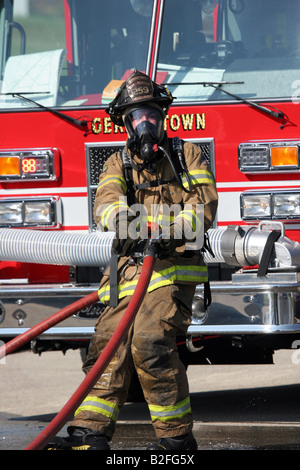 Ein Feuerwehrmann Schlauch an eine Szene in Germantown Wisconsin ziehen Stockfoto