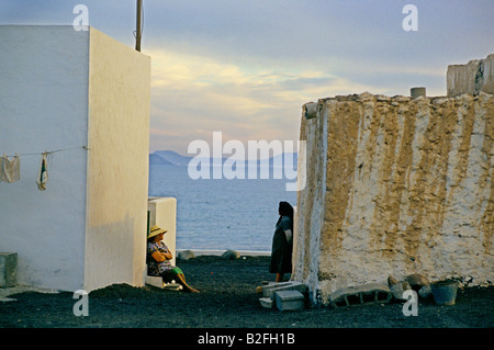 Frau saß auf Treppen mit verschränkten Armen Blick auf das Meer-Playa Blanca Lanzarote Kanarische Inseln Stockfoto