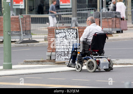Senior woman in Elektro-Scooter lesen Plakat auf Straße Stockfoto