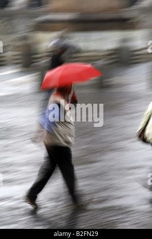 Mann mit Schirm laufen bei starkem Regen in der Stadt Stockfoto