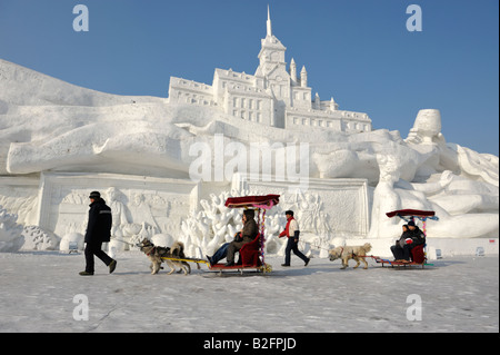 Touristen auf Hundeschlitten bei Schnee und Eis Skulpturen Festival Sun Island Park, Harbin, Provinz Heilongjiang, China Stockfoto