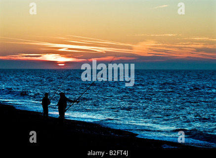 Angeln bei Sonnenuntergang am Strand von Weybourne in Norfolk. Stockfoto