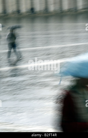 Mann mit Schirm laufen bei starkem Regen in der Stadt Stockfoto