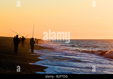 Angeln bei Sonnenuntergang am Strand von Weybourne in Norfolk. Stockfoto