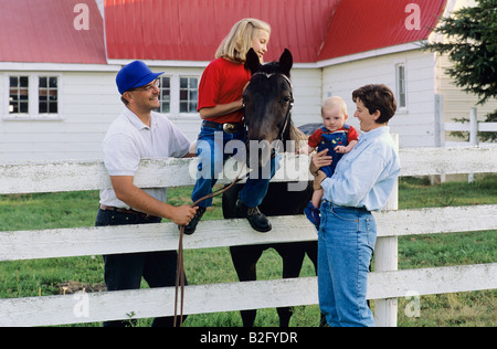 Familie auf Bauernhof mit Pferd Stockfoto