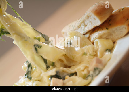 Tagliatelle mit Lachs und Spinat in einer cremigen Sauce und Knoblauchbrot Stockfoto