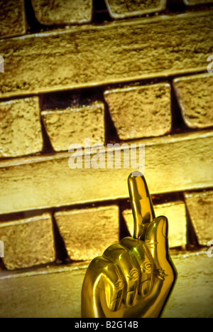 Konzept-Bild der zunehmenden globalen Preis des Goldes mit "Gold Finger" nach oben mit solid gold Barren hinter Stockfoto