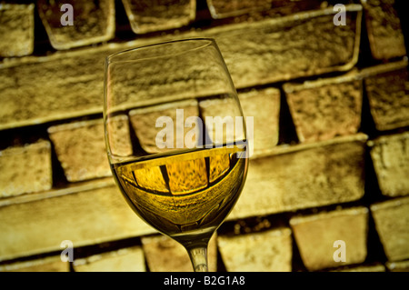 Glas feinen goldenen Vintage Weißwein mit reinem festen Goldbarren spiegelt sich in Glas hinter Stockfoto