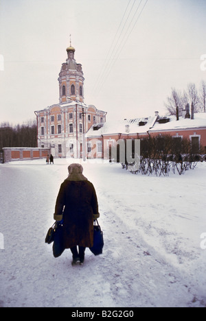 alte Frau mit Taschen in den Schnee in St. petersburg Stockfoto