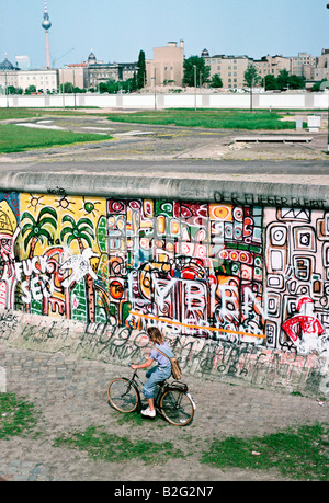 eine Mädchen reitet ihr Fahrrad entlang der Berliner Mauer 1986 Stockfoto