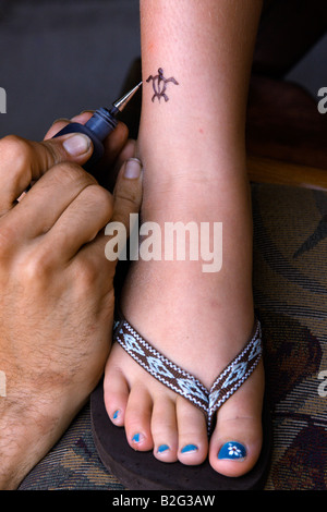 Ein Henna-Tattoo-Künstler arbeitet an einem Kunden s Knöchel in Kaanapali, Hawaii auf der Insel Maui auf 24. Juli 2008. Stockfoto