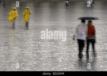 junges Paar teilen einen Regenschirm bei starkem Regen Stockfoto