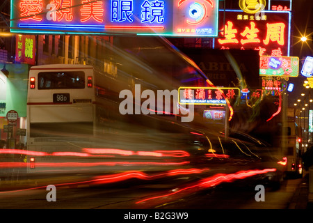 Auto Rückleuchten verwischen inmitten Neon-Schilder an der belebten Nathan Road in Kowloon Hong Kong China Asien in der Nacht Stockfoto