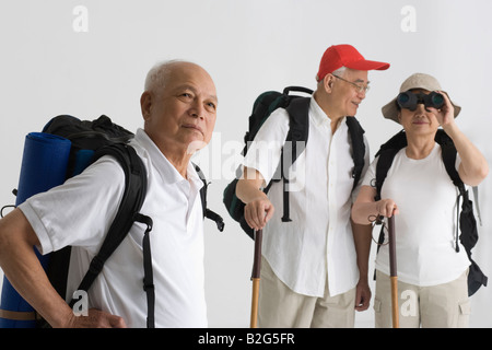 Seitenansicht eines älteren Mannes denken mit seinen Freunden hinter ihm steht Stockfoto