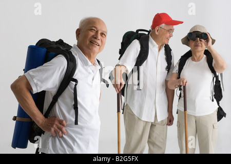 Seitenansicht eines älteren Mannes lächelnd mit seinen Freunden hinter ihm steht Stockfoto