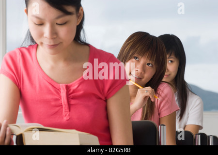 Drei junge Frauen studieren in einem Klassenzimmer Stockfoto
