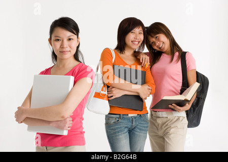 Porträt eines weiblichen Studenten halten einen Laptop und ihre Freunde stehen hinter ihr Stockfoto