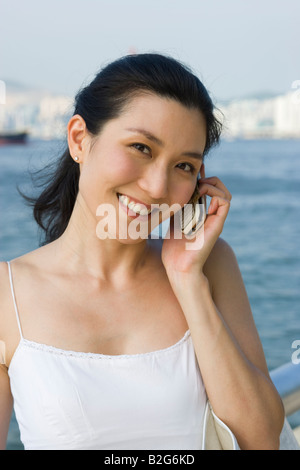 Porträt einer jungen Frau auf einem Mobiltelefon sprechen und Lächeln Stockfoto