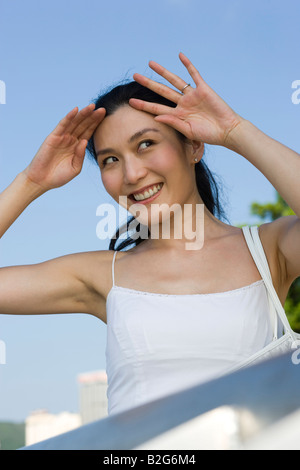 Nahaufnahme einer jungen Frau, die ihre Augen Abschirmung Stockfoto