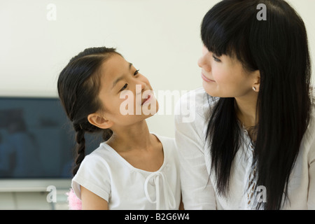 Mitte Erwachsene Frau und ihre Tochter Lächeln einander an Stockfoto