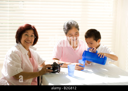 Zwei Frauen in Führungspositionen sitzen mit einem jungen und lächelnd Stockfoto