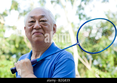 Porträt eines senior hält einen Badminton-Schläger Stockfoto