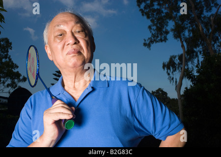 Porträt eines senior hält einen Badminton-Schläger Stockfoto