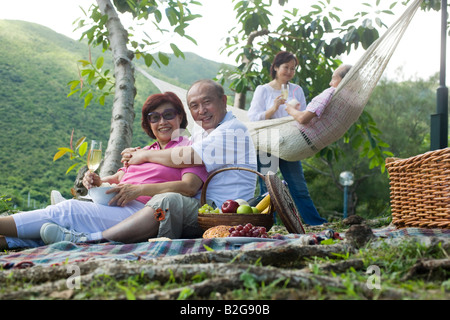 Ältere Mann umarmt eine reife Frau bei einem Picknick Stockfoto