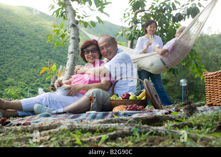 Ältere Mann umarmt eine reife Frau bei einem Picknick Stockfoto