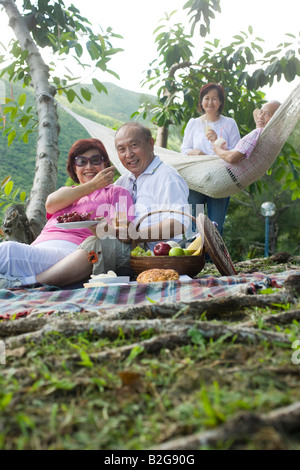 Reife Frau Fütterung eine Traube zu einem älteren Mann bei einem Picknick Stockfoto