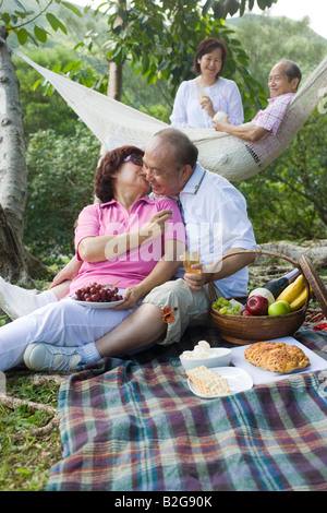 Reife Frau küssen einen senior Mann bei einem Picknick Stockfoto