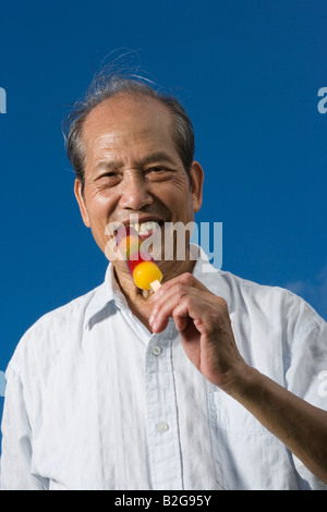 Porträt eines älteren Mannes ein Eis essen und lächelnd Stockfoto