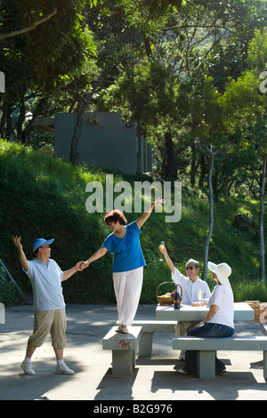 Zwei Paare genießen ein Picknick in einem park Stockfoto