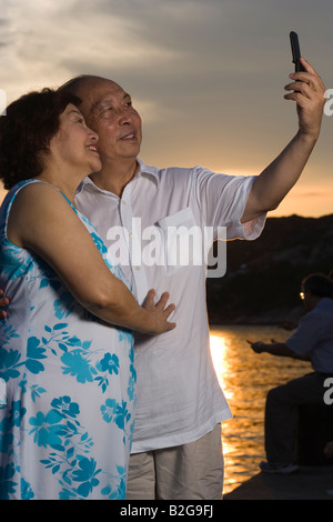 Paar fotografieren sich mit einem Kamera-Handy und lächelnd Stockfoto