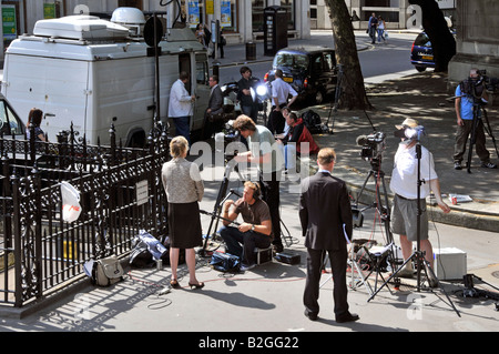 Gegenüber von Royal Courts of Justice Law Courts Journalisten und Reporter mit TV-Kamerateams, die neben der Satellitenschüssel Van London UK Nachrichten schreiben Stockfoto