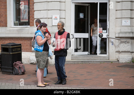 Nordengland UK Juli eine junge Frau mit einem Mann sprechen Verkauf von The Big Issue Stockfoto