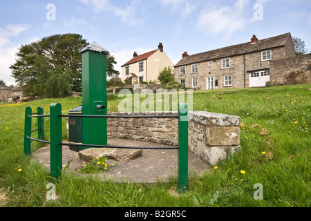 Die alte Wasserpumpe auf dem Dorfplatz am Thornton Steward in North Yorkshire Stockfoto