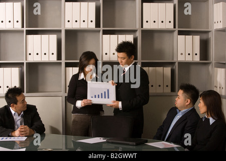 Geschäftsleute, die Diskussion über eine Balkenanzeige im Büro Stockfoto