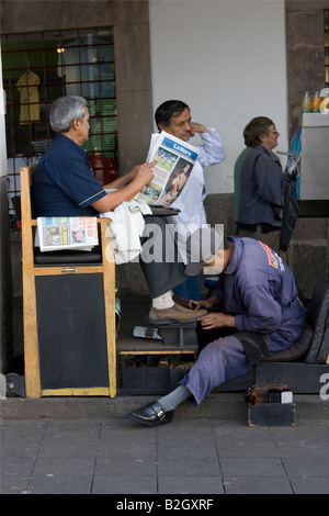 Mann-Schuhputzservice, arbeiten in der Straße. Zeitung lesen. Straßenszene in Quito, Ecuador Süd America.70037 Ecuador Stockfoto