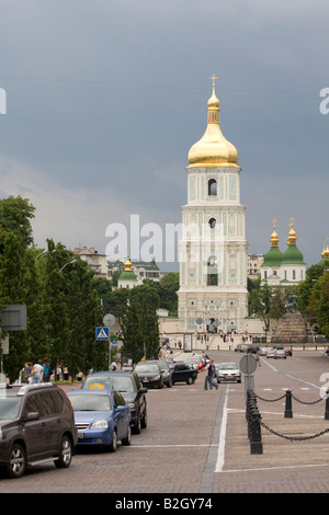 Blick auf die Sophienkathedrale, Kiew, Ukraine. Eine verkehrsreiche Straße, die zum Glockenturm der Sophienkathedrale führt. Fotografiert an einem bewölkten Sommer. Stockfoto