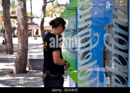 Junger Mann macht Anruf in öffentlichen Telefonzelle der spanische Telekom-Anbieter Telefonica in Cala Ratjada, Mallorca, Spanien Stockfoto