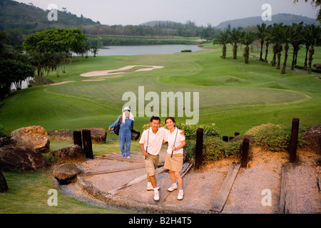 Vogelperspektive Blick auf ein älteres paar holding Golfclubs mit eine Frau im Hintergrund Stockfoto