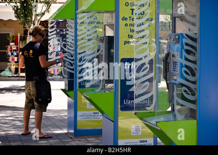 Junger Mann macht Anruf in öffentlichen Telefonzelle der spanische Telekom-Anbieter Telefonica in Cala Ratjada, Mallorca, Spanien Stockfoto