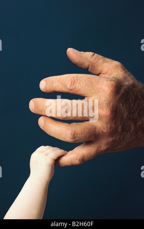 Nahaufnahme des alten Mannes Hand zarte Baby Kind an der Hand zu berühren. Stockfoto